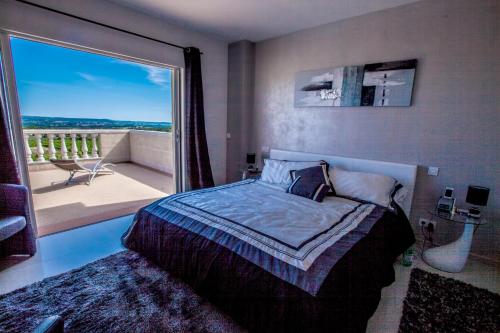 Saint-Jean-de-Fos瓦卢贝尔城堡酒店的一间卧室设有一张床和一个大窗户