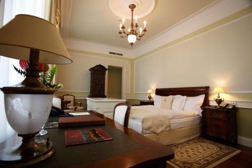 库塔斯海尔特莱卡斯特酒店的一间卧室配有一张床和一张带台灯的桌子