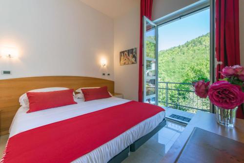Balestrino卡德伯纳酒店的一间卧室设有一张大床和一个大窗户