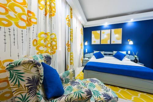布加勒斯特放松舒适套房酒店的蓝色的卧室配有床和沙发