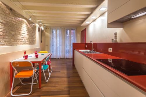 威尼斯Apartments Moon or Dama的厨房配有桌椅和水槽。