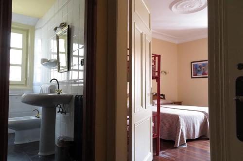 柯米拉斯埃斯梅拉达旅馆的一间带水槽和浴缸的浴室以及一张床