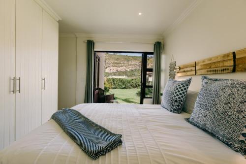 普利登堡湾Whale Rock Gardens 15 - partial inverter的卧室配有带蓝色枕头的大型白色床