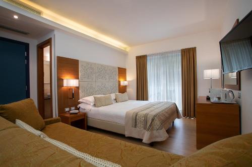 利尼亚诺萨比亚多罗丹尼尔酒店的一间酒店客房,配有一张床和一台电视
