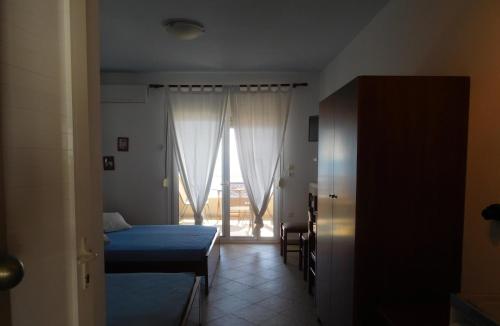 新马尔马拉斯斯特凡公寓的一间卧室设有一张床,一扇门通往窗户