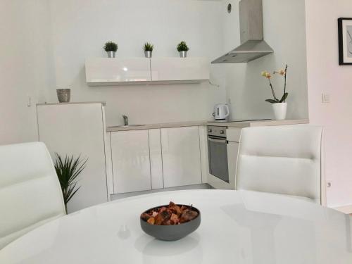 萨格勒布Ocean Apartment的厨房配有一碗水果,放在白色的桌子上