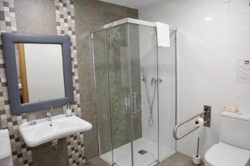MondariaHostal Rural Villa de Mendavia的一间带玻璃淋浴和水槽的浴室