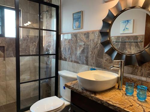 库尔克岛Bay Towers的一间带水槽、卫生间和镜子的浴室
