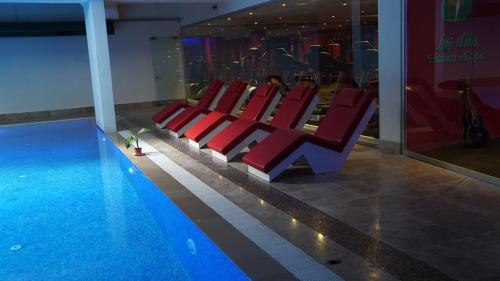 伊斯坦布尔My Palace Rooms Hotel SAW的游泳池旁的一排红色椅子