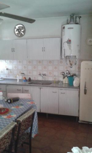 佩尔加米诺Casa habitacion的厨房配有白色橱柜、桌子和冰箱。