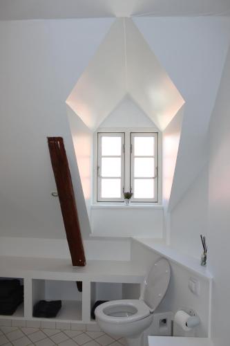 KokkedalKildegaarden的白色的浴室设有卫生间和窗户。