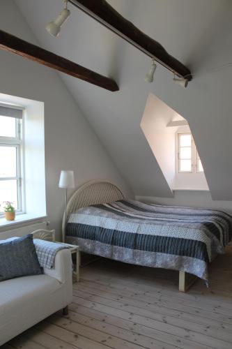 KokkedalKildegaarden的阁楼上一间卧室配有一张床和一张沙发