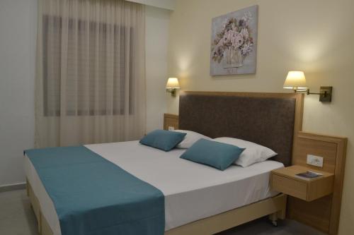 法拉萨纳Romantica Apartments的一间卧室配有一张大床和两个蓝色枕头