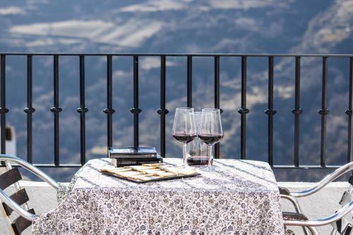 卡皮雷拉维斯塔卫莱达公寓酒店的阳台上的桌子和两杯葡萄酒