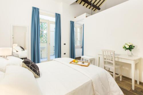 卡利亚里Residenza le Scalette的一间白色卧室,配有两张床和一张书桌