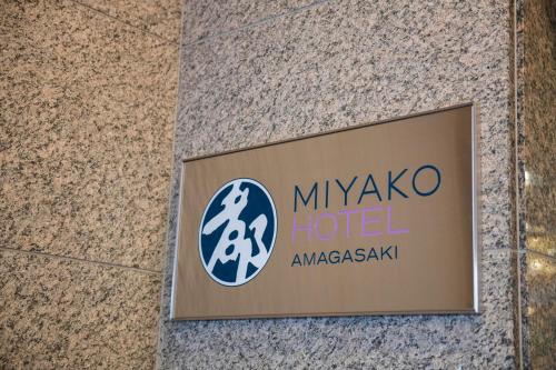 尼崎市Miyako Hotel Amagasaki的大楼里米科诺斯酒店的一个标志