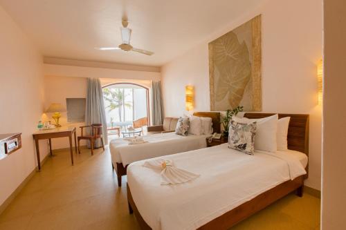 帕纳吉Prainha Resort By The Sea的酒店客房设有两张床和一张桌子。