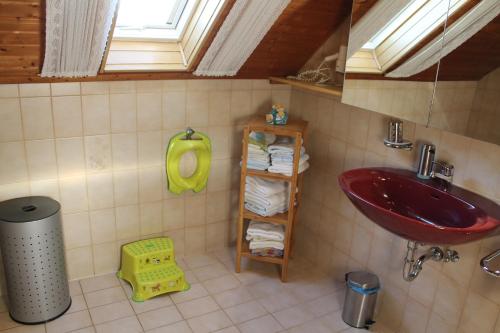 鲁斯特Fewo Schmider的浴室设有红色水槽和带毛巾的架子。