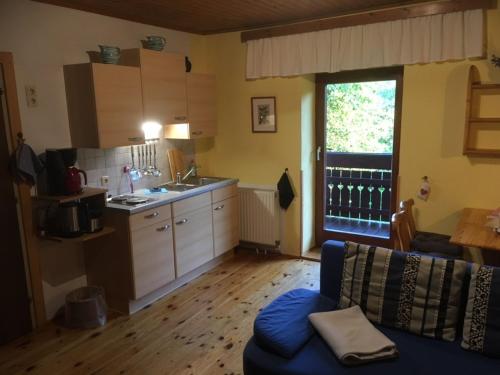 昂特保科洛佩因Appartement Georg的一间带蓝色沙发的客厅和一间厨房