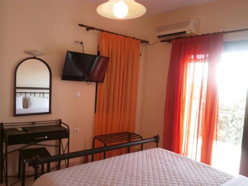 迈加洛丘里Flisvos Apartments的一间卧室配有一张床、一台电视和一面镜子