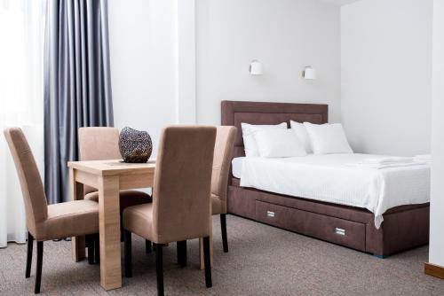 波德戈里察IPN APARTMENTs的卧室配有一张床和一张桌子及椅子