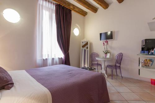 维罗纳Giardino Giusti House & Court的一间卧室配有一张床、一张桌子和一个窗户。