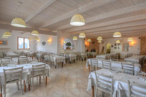 菲纳莱利古雷La Locanda di Cucco的一间设有白色桌椅的用餐室