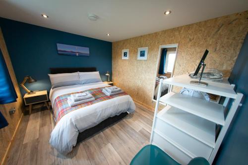 StruanLochanside的一间卧室设有一张床和蓝色的墙壁