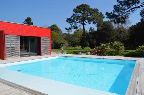 多吕多勒龙Les Naiades的一座红色建筑中的游泳池