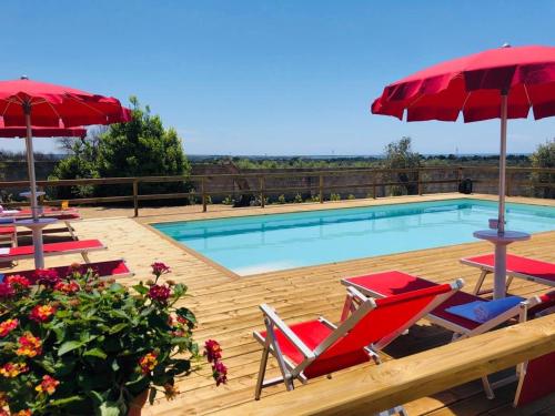 加利波利B&B Villa Jonica的甲板上配有椅子和遮阳伞的游泳池