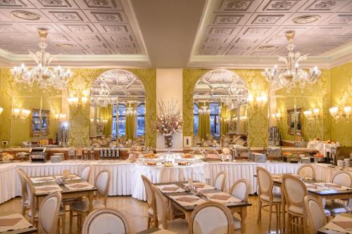 威尼斯普林西皮酒店的用餐室配有桌椅和吊灯。