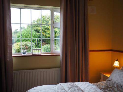 纳斯Inglewood Lodge B&B的一间卧室设有一张床和一个大窗户