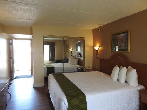 罗马瑞拉克斯公寓的配有一张大床和镜子的酒店客房