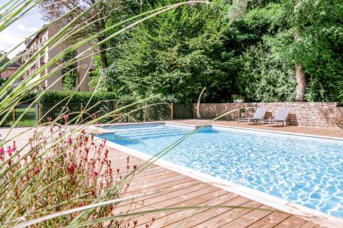 莫斯特约勒斯缪斯和罗齐尔酒店的庭院中带木制甲板和椅子的游泳池