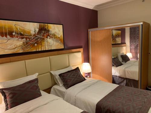 麦加Altelal Apartment的酒店客房,设有两张床和镜子