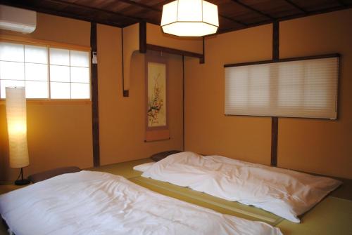 奈良NARAigoto EENA HOUSE的卧室配有白色床、灯和窗户