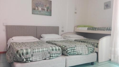 加尔达湖滨安布拉公寓酒店的客房设有两张床和一张双层床。