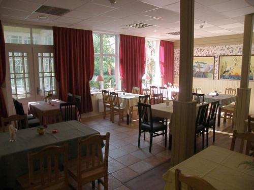 派尔努Villa Katariina的一间带桌椅和红色窗帘的餐厅