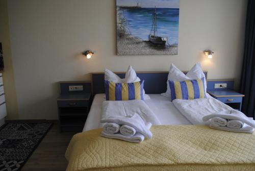 奥斯赛拜-屈隆斯博恩Ferienwohnung Yachthafenperle的一间卧室配有两张带毛巾的床