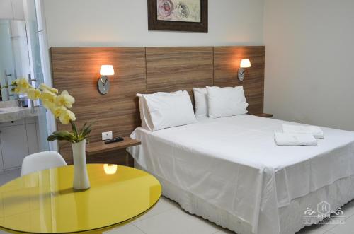 关那比Hotel das Torres的酒店客房设有一张床铺和一张黄色的桌子。