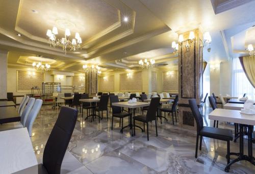 加格拉Sun Palace Gagra的一间在房间内配有桌椅的餐厅