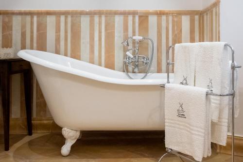 皮蒂利亚诺柴考提诺旅馆的浴室设有白色浴缸,配有毛巾