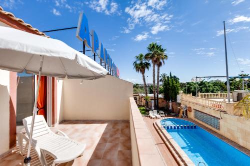 托雷维耶哈Apartamentos Atlas的一个带遮阳伞和游泳池的庭院