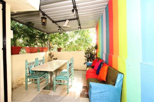 孟买Town Hostel Mumbai - AC Dormitory的庭院设有桌椅和色彩缤纷的墙壁。
