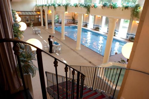 盖特豪斯厄夫弗利特Cally Palace Hotel & Golf Course的站在建筑物游泳池前的妇女
