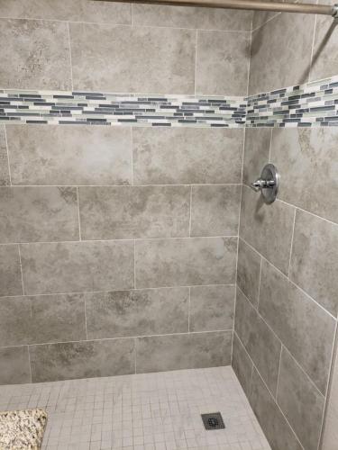 埃尔森特罗经典旅馆及套房酒店的带淋浴的浴室,铺有瓷砖地板。