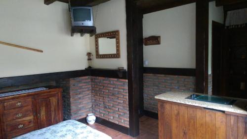 蓬特维耶斯戈Entre Puentes的一个带水槽的厨房和墙上的电视