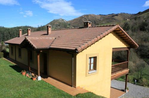 里瓦德塞利亚Casa Rural La Llosica的一座带屋顶的黄色小房子