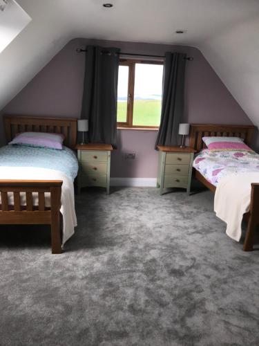 LochalineTigh a Chabar的阁楼卧室设有两张床和窗户。