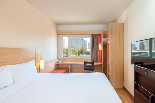 圣地亚哥圣地亚哥中心宜必思酒店的配有一张床、一张书桌和一扇窗户的酒店客房